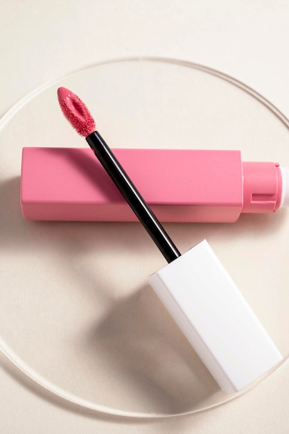 오픈 튜브 메이크업 화장품 제품 중성 따뜻한 배경이 있는 핑크색 액체 립스틱 및 애플리케이터 브러시