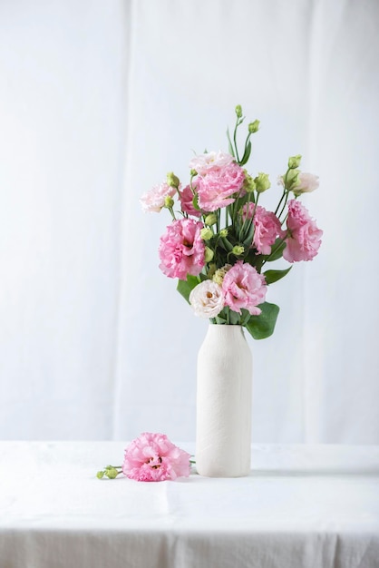 Pink lisianthus flowers in white vase