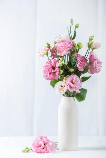 Pink lisianthus flowers in white vase