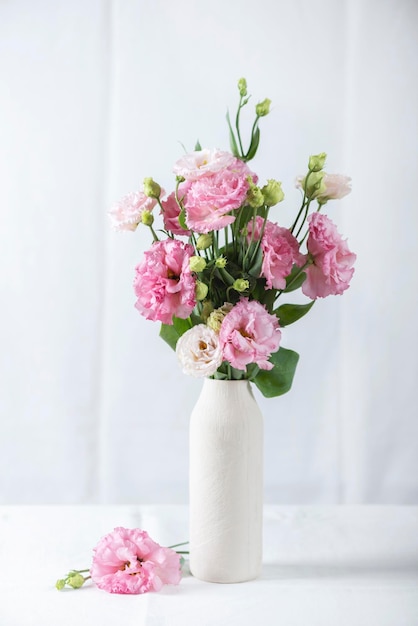 Pink lisianthus flowers in white vase