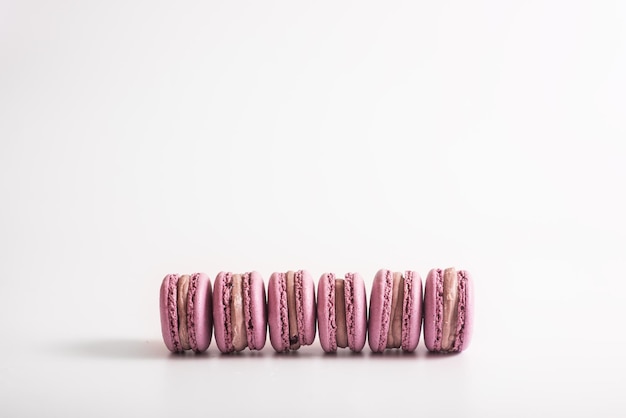 Розовое макаронное печенье на белом фоне Вкусный десерт