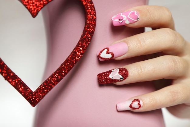 Pink manicure on long nails with hearts