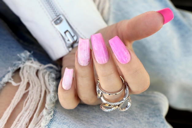 Pink manicure with long nails with a ring