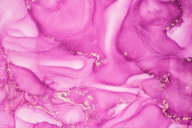 A pink marble with gold paint on it