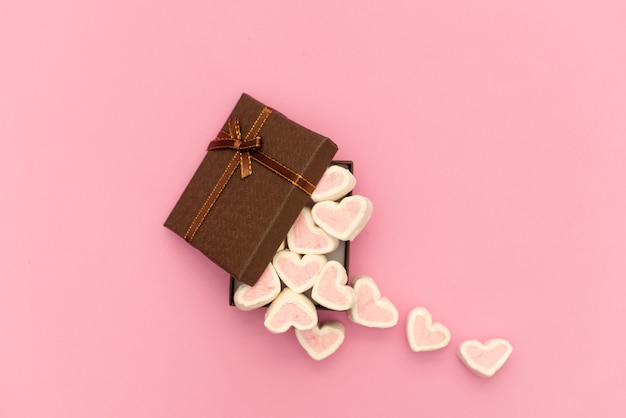 Foto marshmallow rosa in una confezione regalo a forma di cuore su sfondo tessile, molti cuori marshmallows per regalo, dolci a forma di cuori di marshmallow. regalo di san valentino