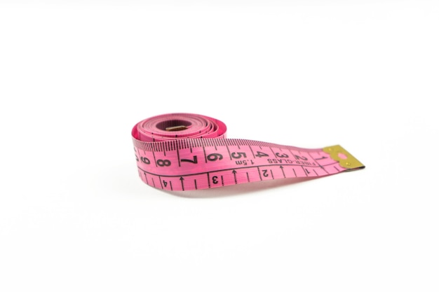 A pink measuring tape lies on a white table