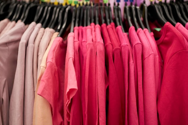 pink men's t-shirts on hangers in a clothing store. Men's pink t-shirts hanging on hangers in the st