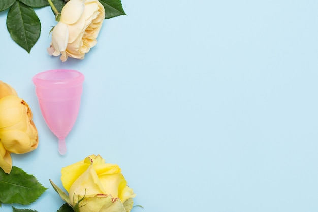 Pink menstrual cup lies on blue