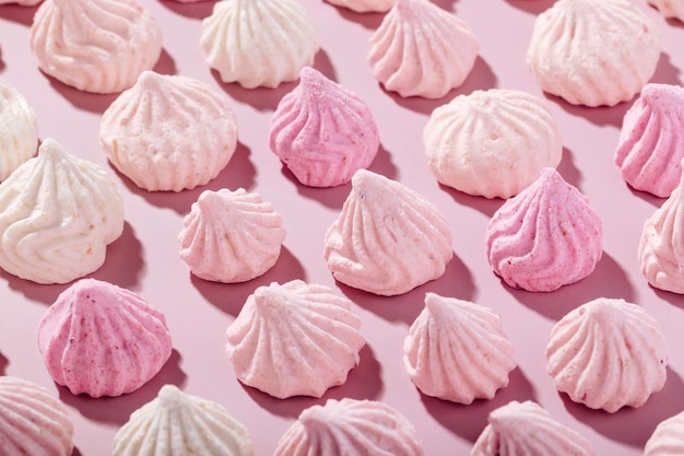 Photo pink meringue cookies with berry flavor on a pink background