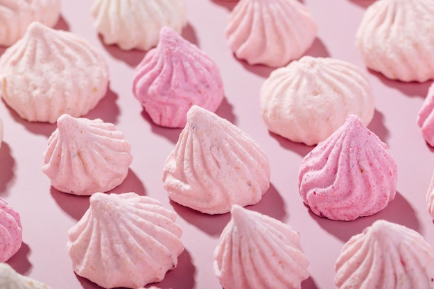 Photo pink meringue cookies with berry flavor on a pink background