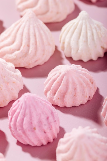 Pink meringue cookies with berry flavor on a pink background