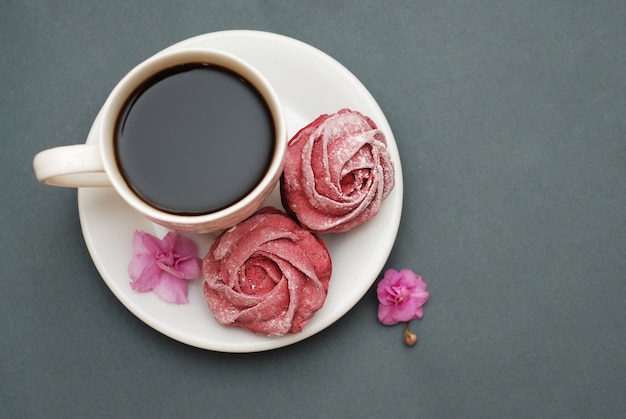 Pink meringues and cup of coffee.