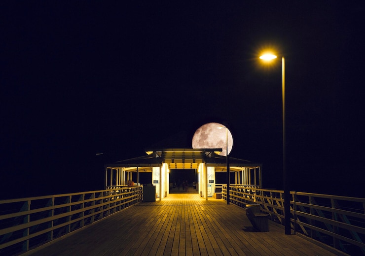 Photo pink moon over the pier empty pier with the lonely moon