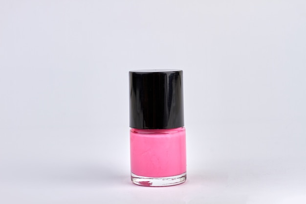 Pink nail polish bottle isolated on white. pink nail varnish\
close up.