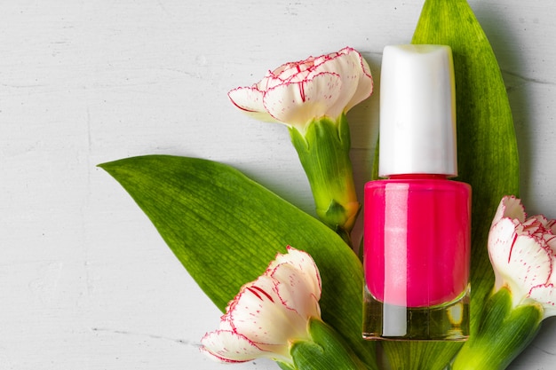 Pink nail polish bottle with flower buds