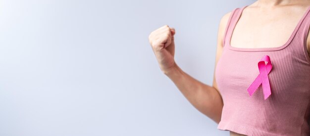 Pink October Breast Cancer Awareness month woman hand hold pink Ribbon and wear shirt for support people life and illness National cancer survivors month Mother and World cancer day concept