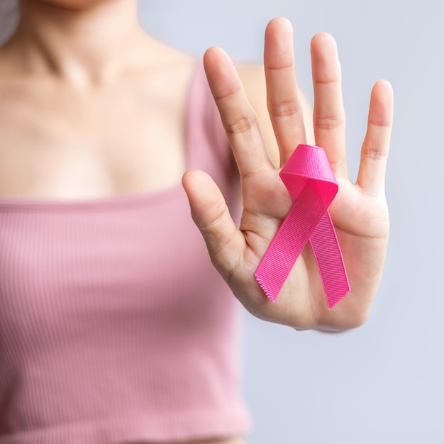 Pink October Breast Cancer Awareness month woman hand hold pink Ribbon and wear shirt for support people life and illness National cancer survivors month Mother and World cancer day concept