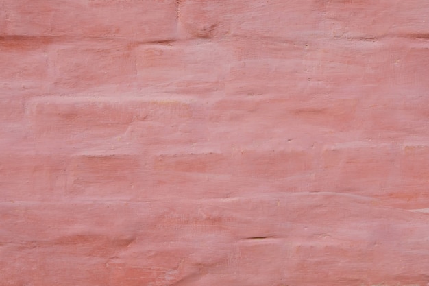 Pink old wall with shabby damaged plaster cement and brick