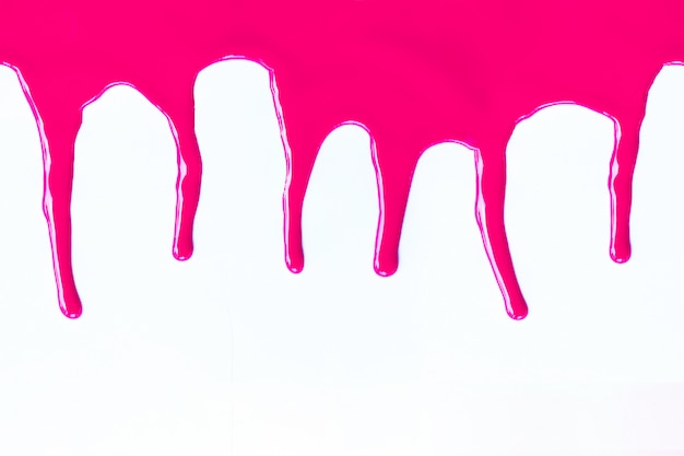 Pink paint dripping on a white. 