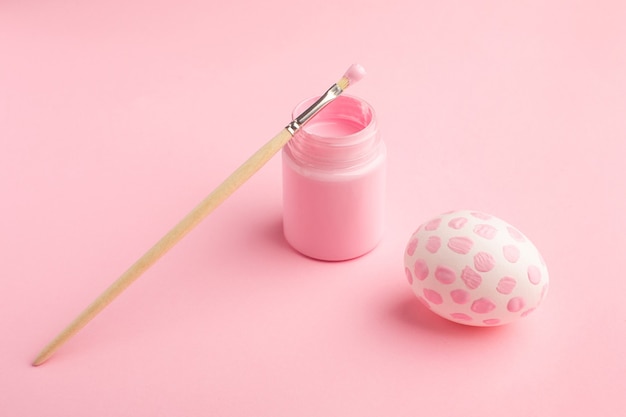 Pink painted easter egg and paint brush. Easter holiday concept.