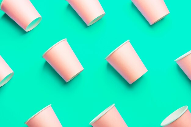 Photo pink paper cups on green background