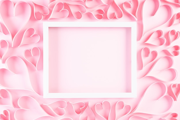 Розовые бумажные сердечки с белой рамкой. любовь и день святого валентина концепции.