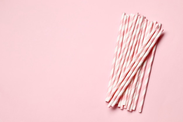 Pink paper straws on a pink background with place for text.