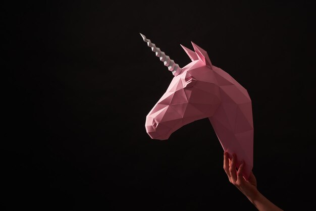 Pink paper unicorn's head on black background