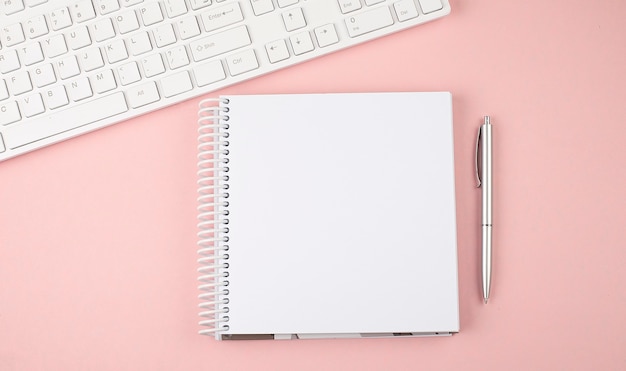 Pink pastel woman office desk with keyboard and notebook .Top view with copy space