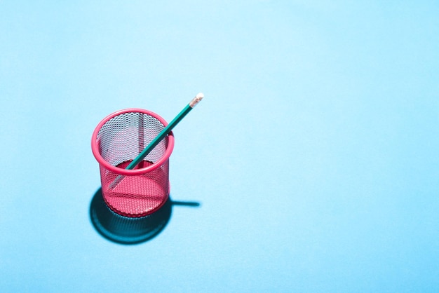 PInk pencil cup on blue background