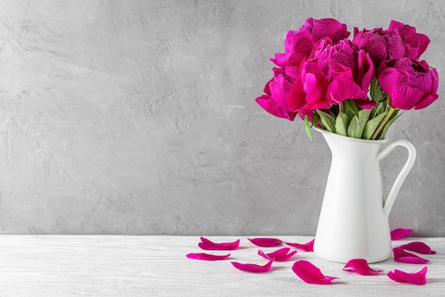 흰색 나무 테이블 정물 축제 배경에 꽃병에 물 방울과 핑크 모란 꽃