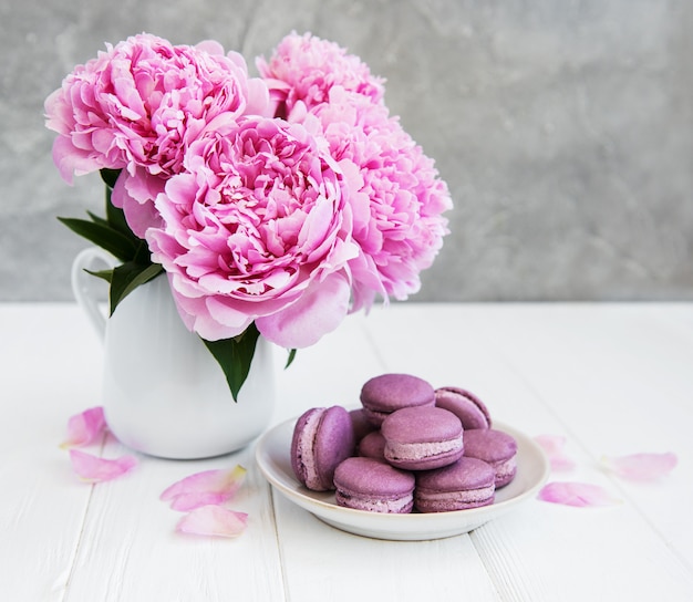 Pink roses petals in bowl with towels and pure water over white