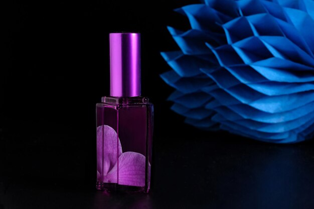 Pink perfume bottle on a black background Side view closeup
