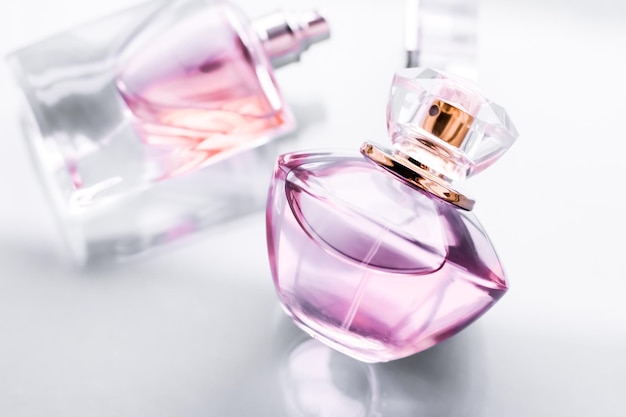 Розовый флакон духов на глянцевом фоне, сладкий цветочный аромат, гламурный аромат и парфюмированная вода в качестве праздничного подарка и дизайн бренда роскошной косметики