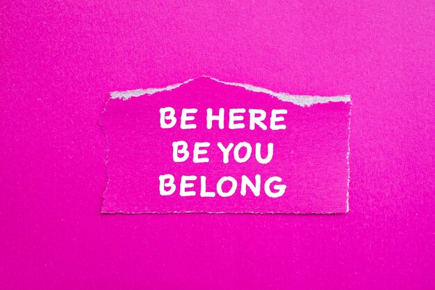 Photo a pink piece of paper with the words be here you be written on it