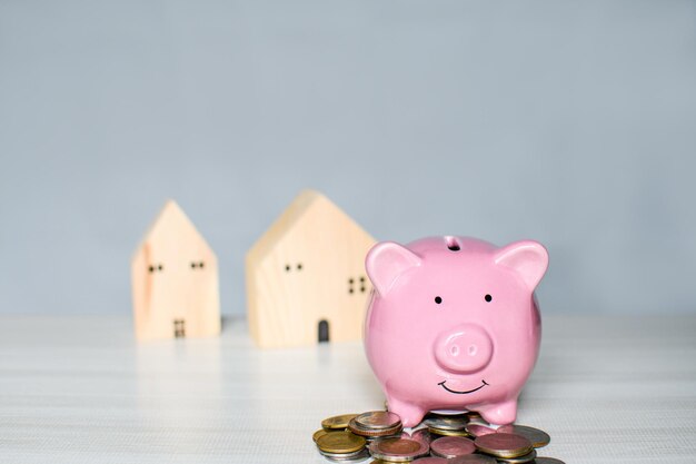 Pink pig piggy bank on a pile the coin is placed on a wooden counter Concept for Finance Banking Savings Interest Business Loan Tax Closeup copy space on top for design blurred background