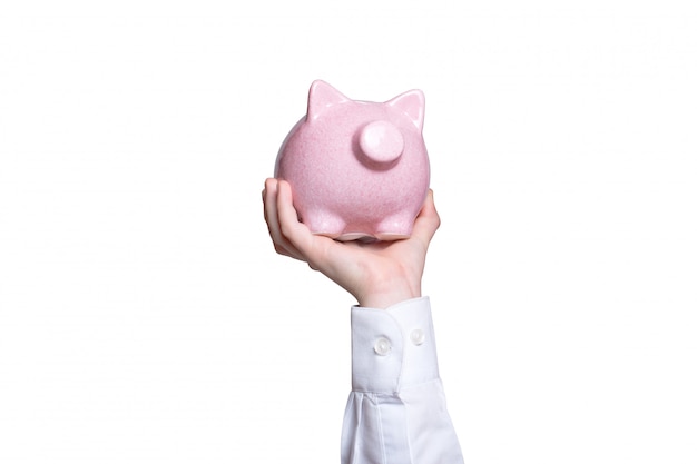 Pink piggy bank in child's hand. Close-up. Business concept. Isolate