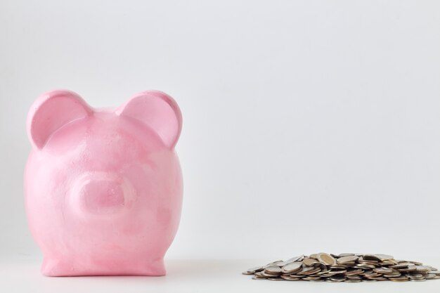 Pink piggy bank and coins On White