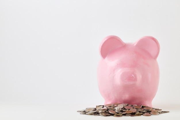 Pink piggy bank and coins On White