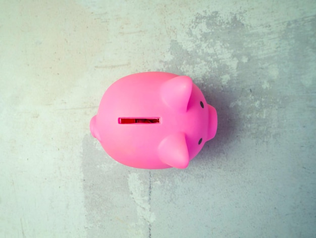 Pink piggy bank on gray concrete backgroundcopy space