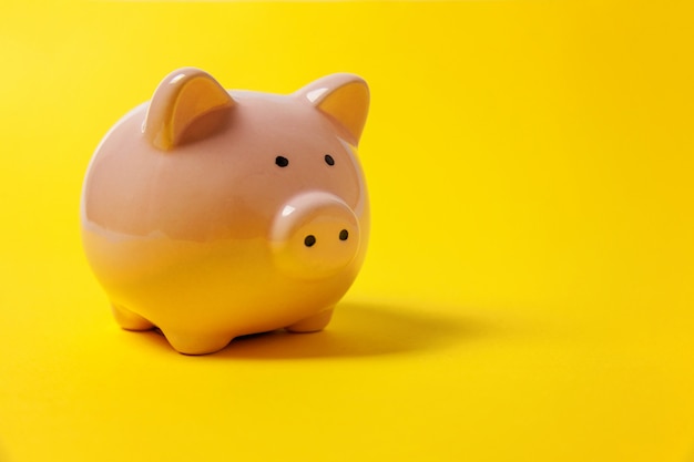 Pink piggy bank isolated on yellow background