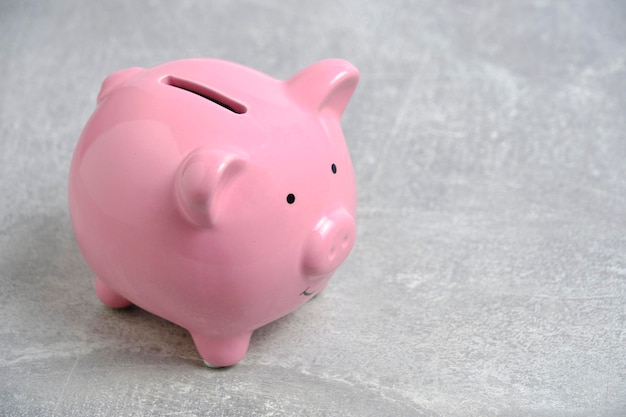 Pink piggy bank light concrete background