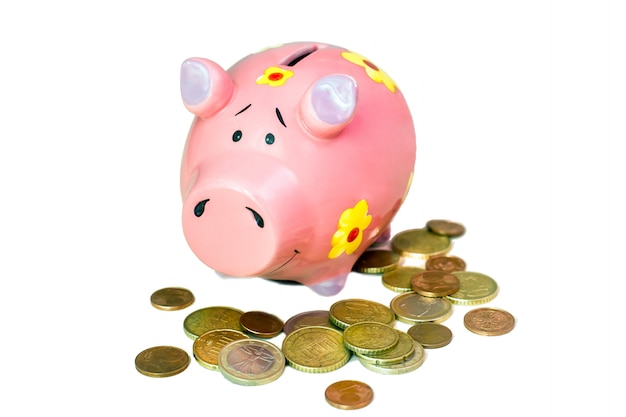 Pink piggy bank and a lot of Euro coins isolated on white