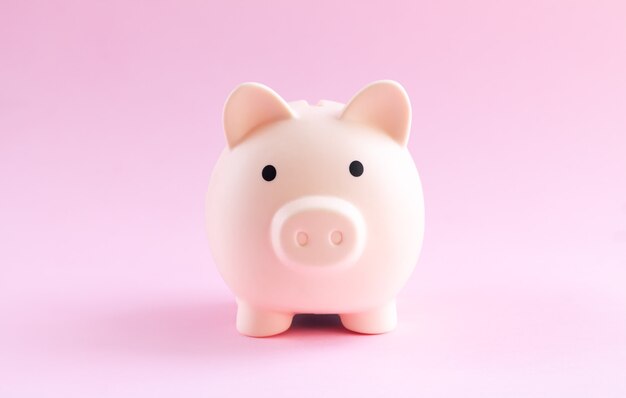 Photo pink piggy bank on pink background close-up. saving money concept