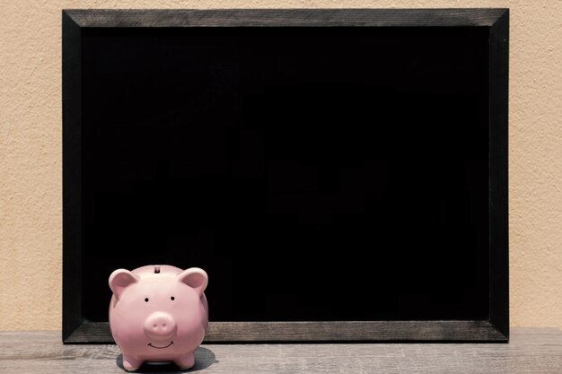 Pink piggy bank with black background, Protect savings, Protect capital, Protect retirement fund concept.