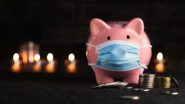 Pink piggy bank with coins on a dark background