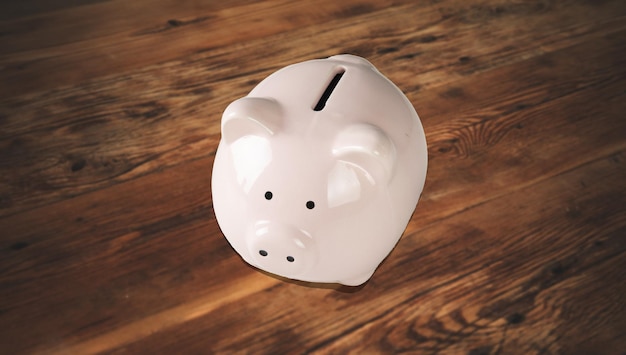 Pink piggy bank on wooden table