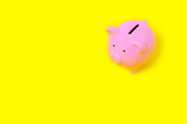 Pink Piggy Bank on Yellow Background.