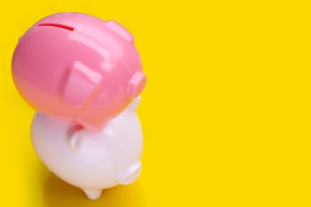 Pink piggy bank on yellow background