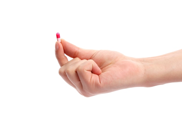 Pink pill in hand isolated on white background